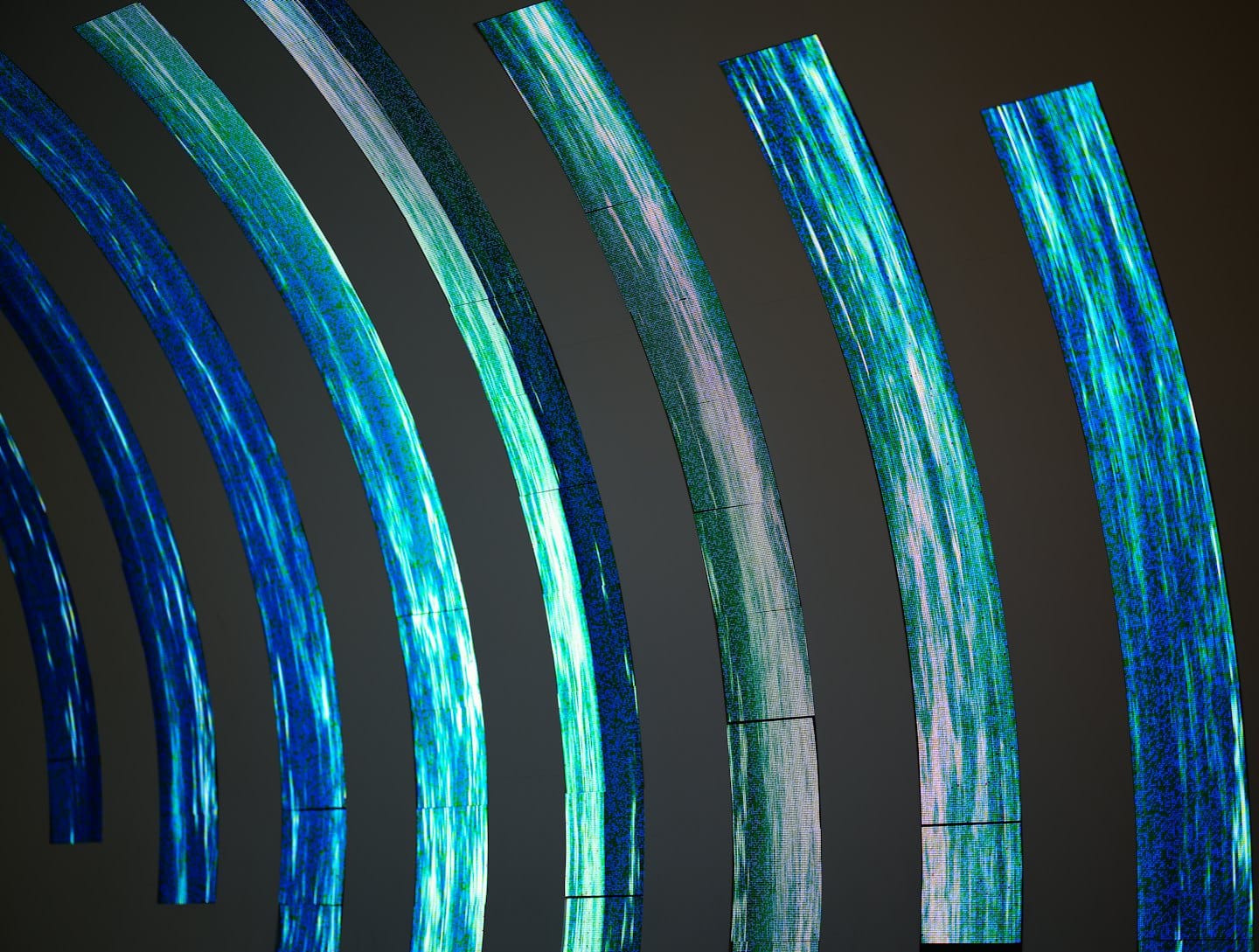 Glowing blue and green light bands form abstract digital curves.